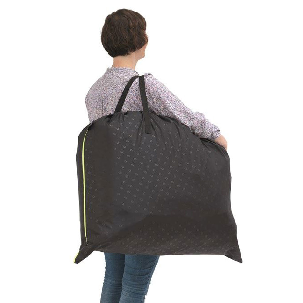 Eine Person trägt das zusammengefaltete Sofa in einer schwarzen Tragetasche. 