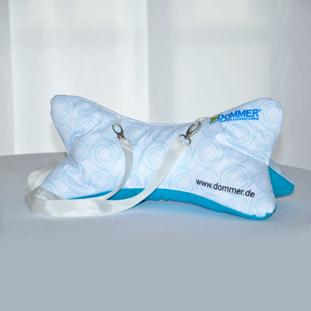 Ein Nackenkissen mit einem blau-weißen Spiralmuster und einem Tragegurt.